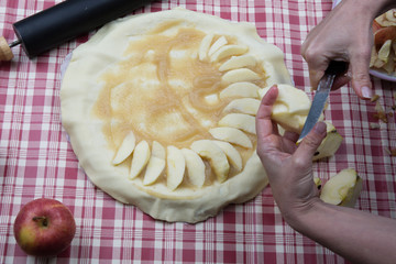 Women making homemade pie with apples on vintage tablecloth