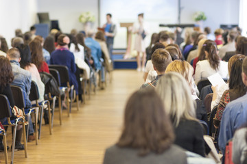 Two Hosts Speaking In front of the Large Group of People