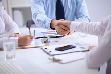 Business people handshake, sitting at the table