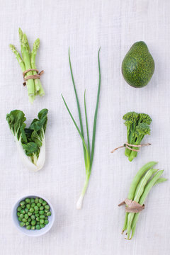 Fresh green vegetables variety on rustic white background from t