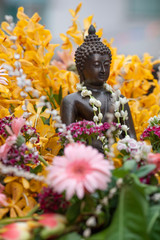 A Buddha statue covered with flower petals