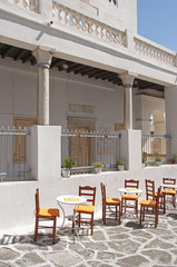 Chairs and tables outside of a public building in Mykonos