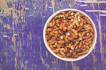 Walnut Kernels in Bowl on Rustic Wooden Background