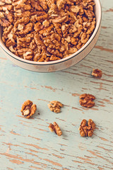 Walnut Kernels in Bowl on Rustic Wooden Background
