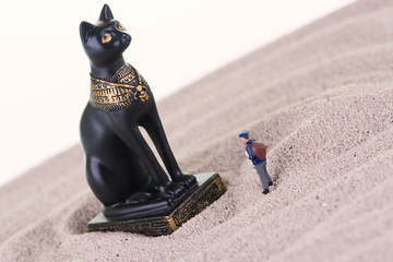 Miniature tourist with the Egyptian guardian Bastet statue 