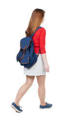 Naklejka premium back view of walking woman in dress with backpack.