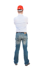Backview of an engineer in construction helmet stands
