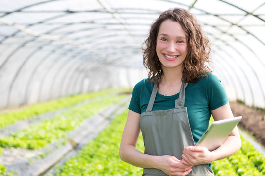 Portrait of an attractive farmer in a greenhouse using tablet
