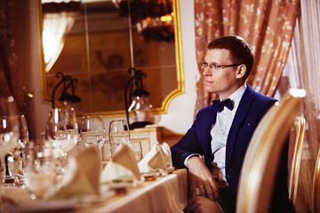 Elegant dressed businessman in glasses in luxury restaurant