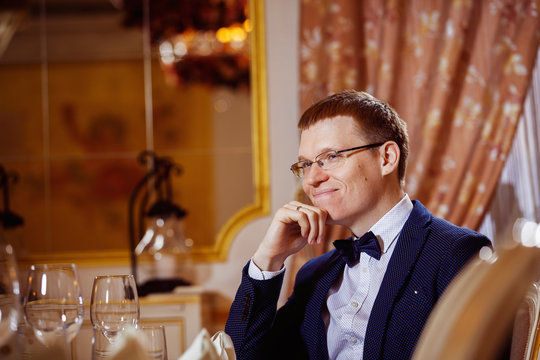 Elegant dressed cheerful red hair businessman in glasses