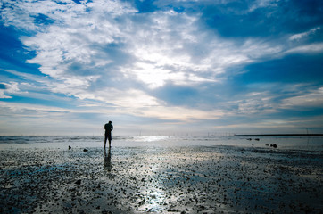 man silhouette standing at the beach