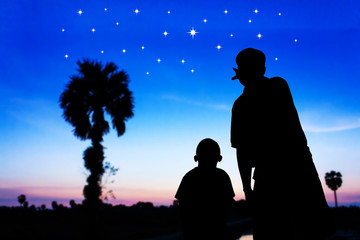 father and son look at the full moon