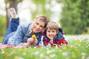 Smiling young woman having a picnic with her cute little son