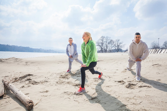 Three Young Athletes Exercising On The Beach