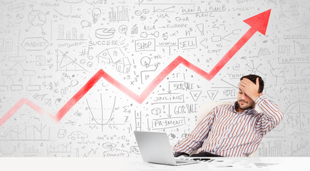 Business man sitting at table with market diagrams