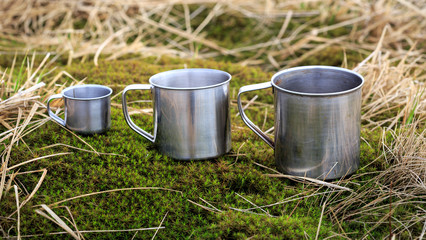 three steel cups on grass