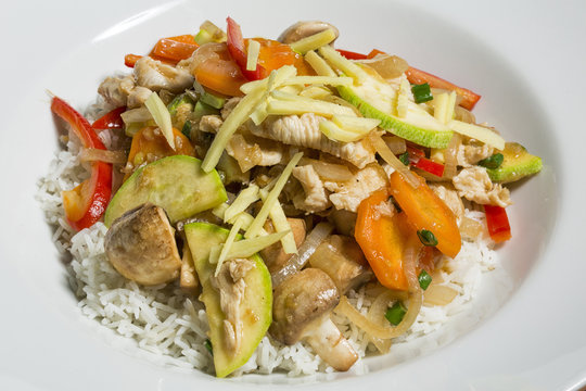Thai food - meat and vegetable stir fry with ginger on rice