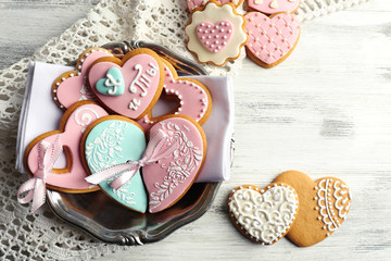 Heart shaped cookies for valentines day on plate, on color wooden background