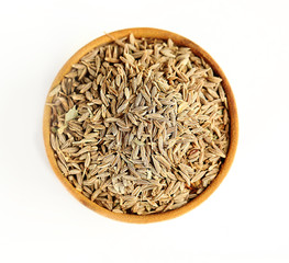 Cumin in wooden bowl, isolated on white