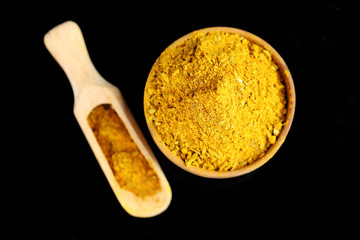 Curry in wooden bowl, isolated on black