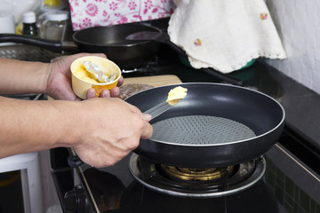 Chef putting butter to the pan