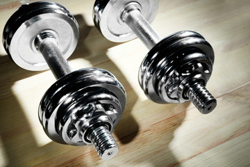 Dumbbells on wooden floor background