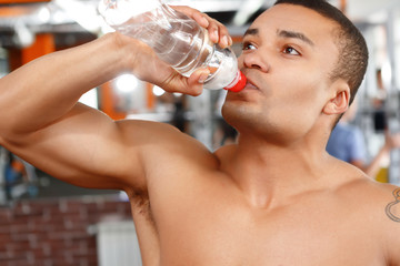 Obraz premium Man drinking water in sport gym