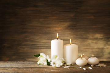 Fototapeta na wymiar Candles with flowers on wooden background