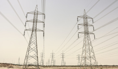Electricity pylons with power plant in the desert