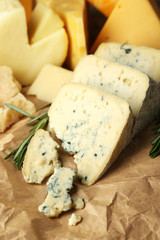 Various types of cheese with rosemary on table close up
