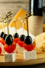 Cheese canapes with wine on table close up