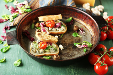 Tasty sandwiches on old pan, on wooden table