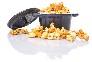 Caramel popcorn in blue pot over white background