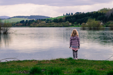 Fototapeta na wymiar girl standing in the waterside of pond