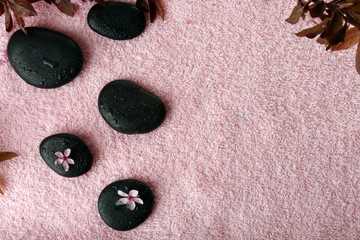 Spa stones and spring flowers on towel background