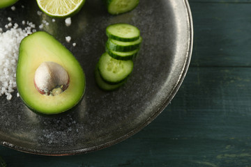 Sliced avocado, cucumber/ pepper and lemon lime on wooden background