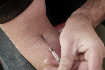 Fototapeta premium Man injecting himself with a small hypodermic