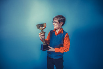 European-looking  boy of ten years in glasses holding a cup awar
