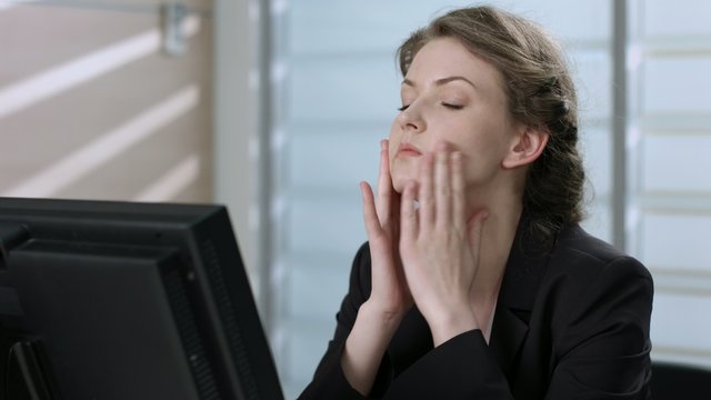 Tired manager working at a computer. Headache. 