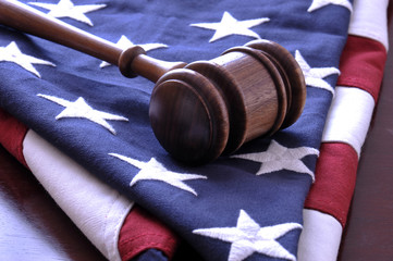 Wooden judge's gavel and American flag.