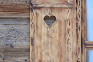 Window blind of a wooden hut with a heart shaped hole - 83083261
