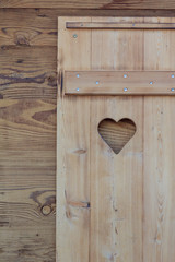 Window blind of a wooden hut with a heart shaped hole - 83083295