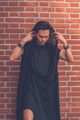 Naklejka premium Handsome Asian model posing in the city streets