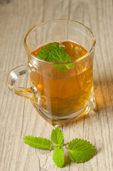 cup of tea with mint on wooden table