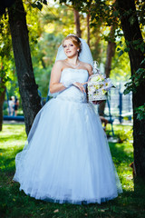 Obraz na płótnie Canvas Beautiful bride posing outdoor at the park in her wedding day