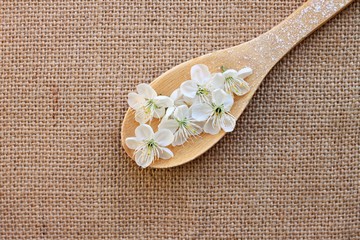 kitchen wooden spoon with blossom jute cloth background