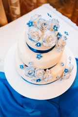 Obraz na płótnie Canvas multi level white wedding cake on silver base and pink flowers