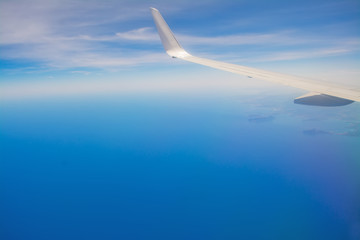 Fototapeta na wymiar white airplane wing in the blue sky