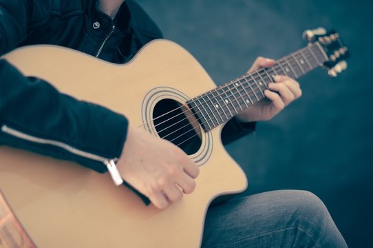 Human hand playing an electric guitar