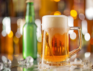 Bottle of beer with glass on bar desk